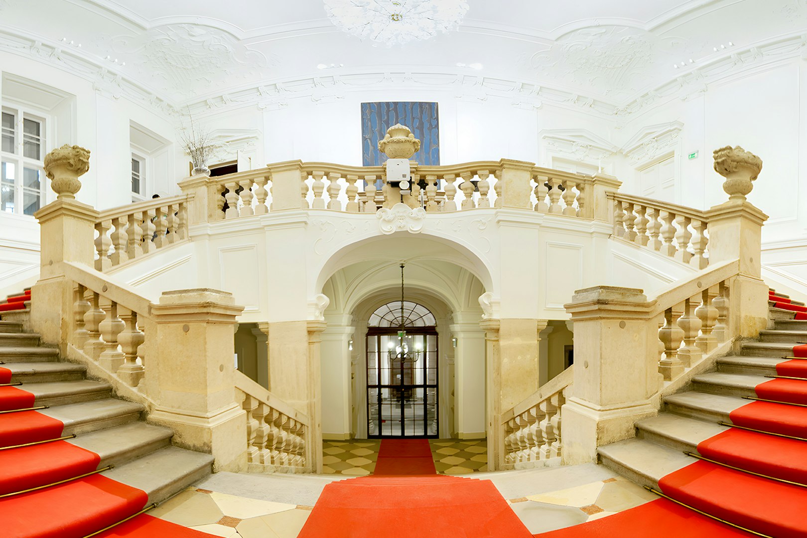 Grand staircase with red carpet at Vienna Baroque Orchestra venue.