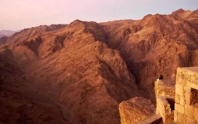 Sunrise view from Mount Sinai summit with rugged mountain landscape.