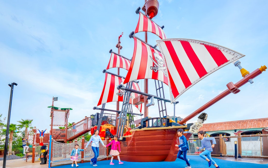 Children playing near a pirate ship attraction at Legoland Japan.