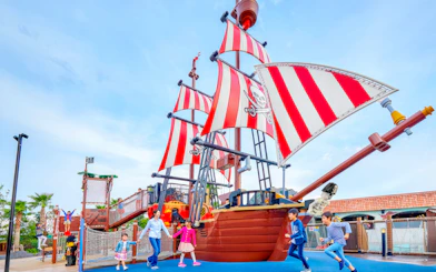 Children playing near a pirate ship attraction at Legoland Japan.