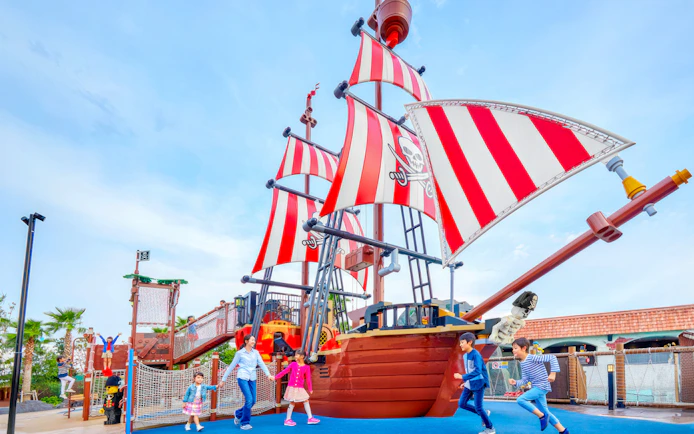 Children playing near a pirate ship attraction at Legoland Japan.
