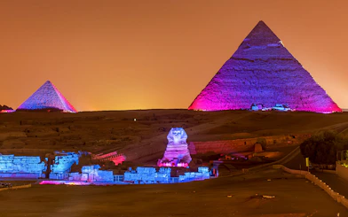 Pyramids and Sphinx illuminated at night, Giza, Egypt.