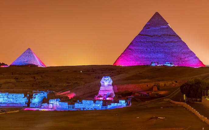 Pyramids and Sphinx illuminated at night, Giza, Egypt.
