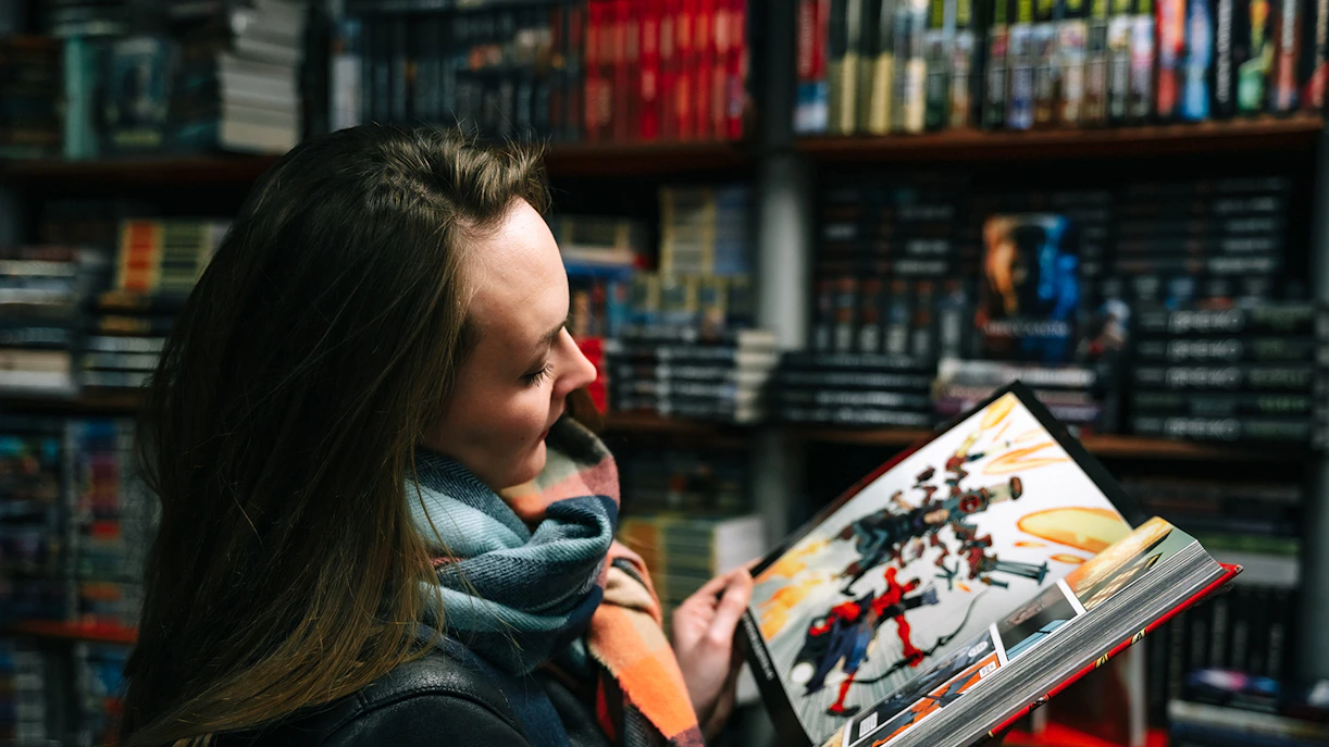 Person reading a comic book in Forbidden Planet, London’s theatre district.