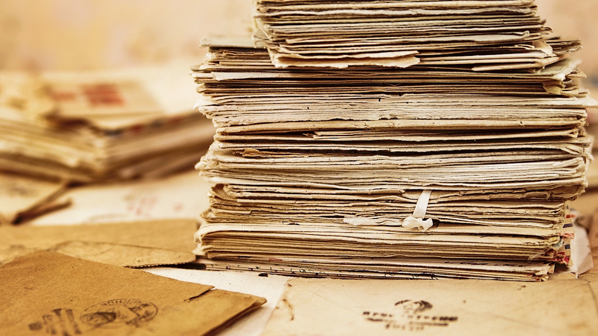Historic documents displayed in a dimly lit archive room in Paris, France.