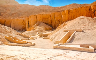 Valley of the Kings tomb entrances in Luxor, Egypt, surrounded by desert cliffs.