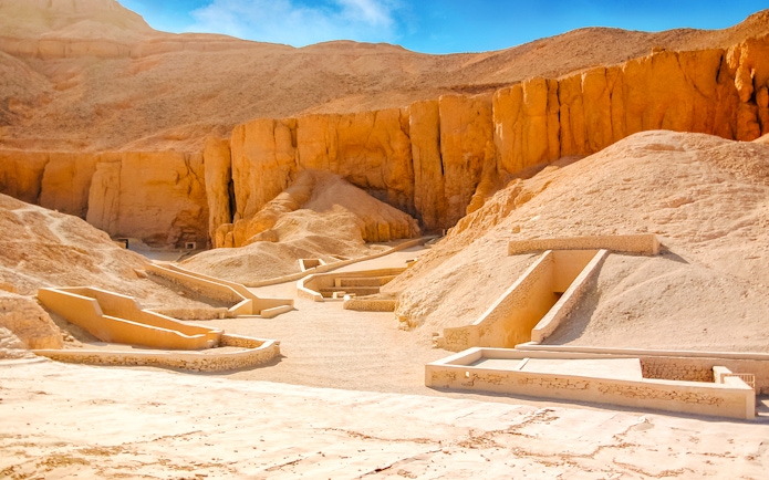 Valley of the Kings tomb entrances in Luxor, Egypt, surrounded by desert cliffs.