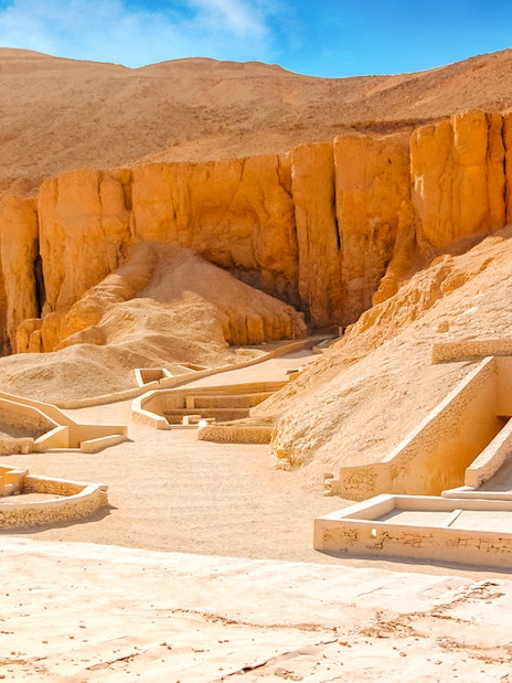 Valley of the Kings tomb entrances in Luxor, Egypt, surrounded by desert cliffs.