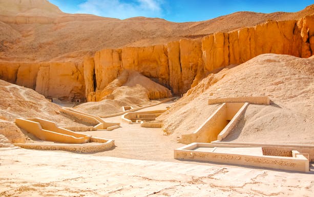 Valley of the Kings tomb entrances in Luxor, Egypt, surrounded by desert cliffs.
