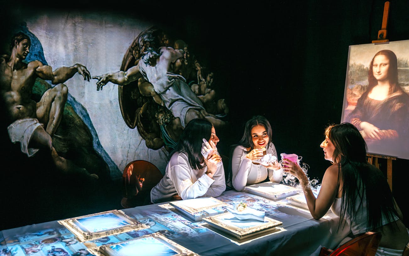 Guests enjoying Seven Paintings Immersive Dining Show with art projections and 7-course menu.