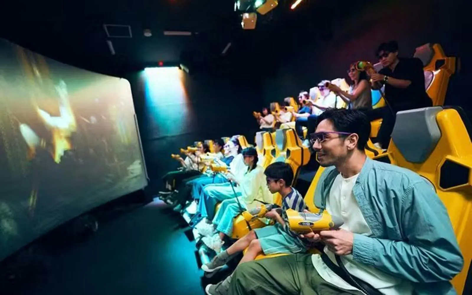 Audience enjoying an immersive experience at Tokyo Dome City with interactive seats and screens.