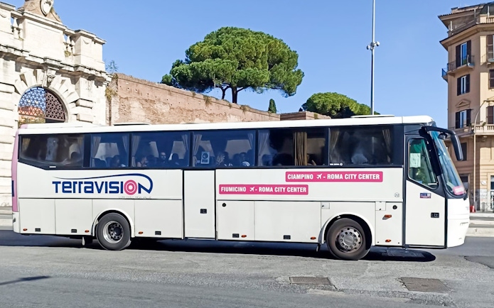 Terravision bus at Rome city center near historical arch, offering airport transfers.
