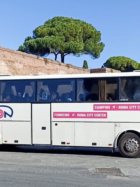 Terravision bus at Rome city center near historical arch, offering airport transfers.