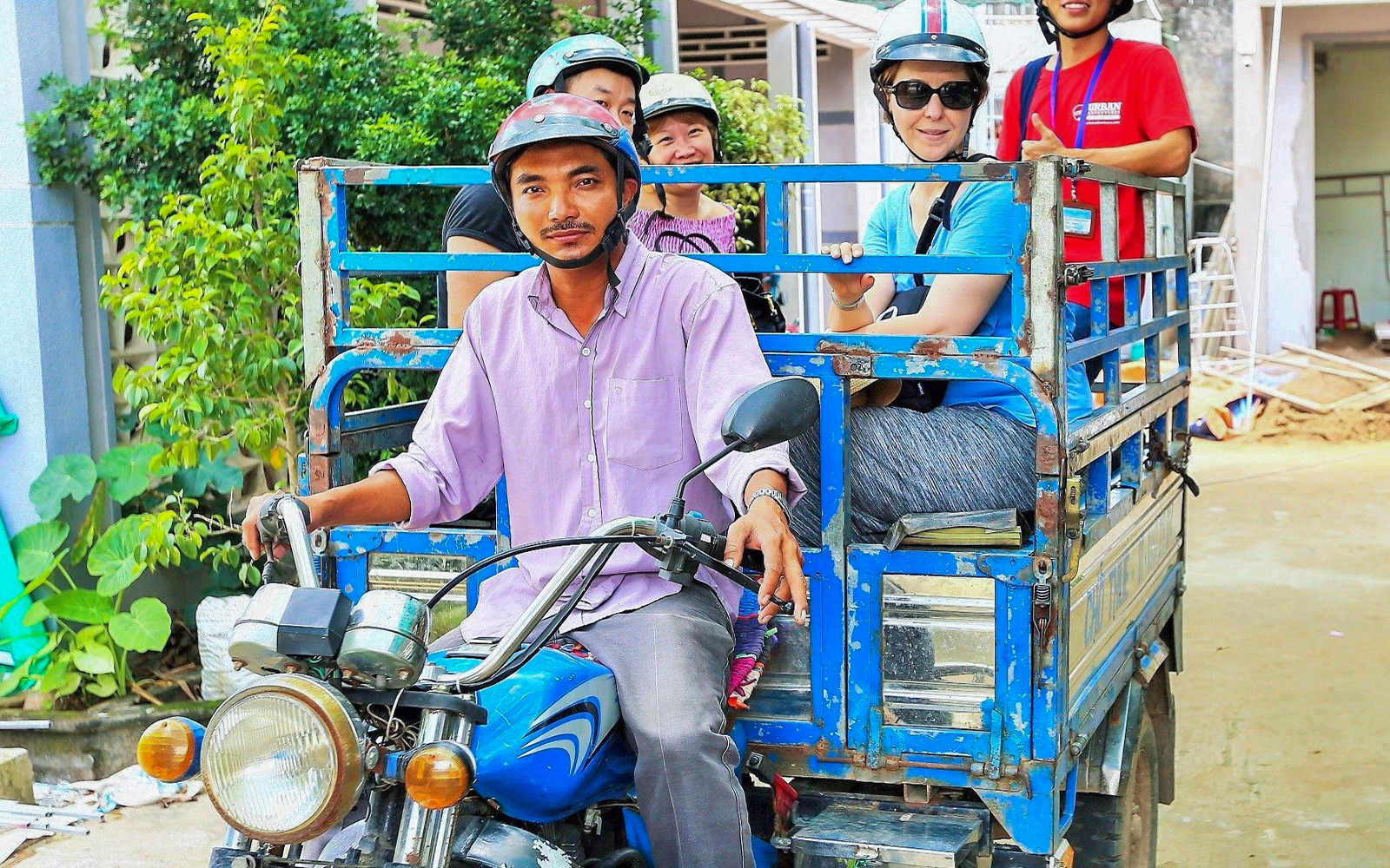 Tourists riding a motorbike cart in the Mekong Delta during a full day tour.