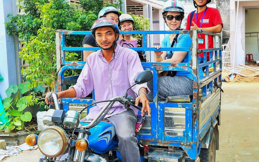 Tourists riding a motorbike cart in the Mekong Delta during a full day tour.