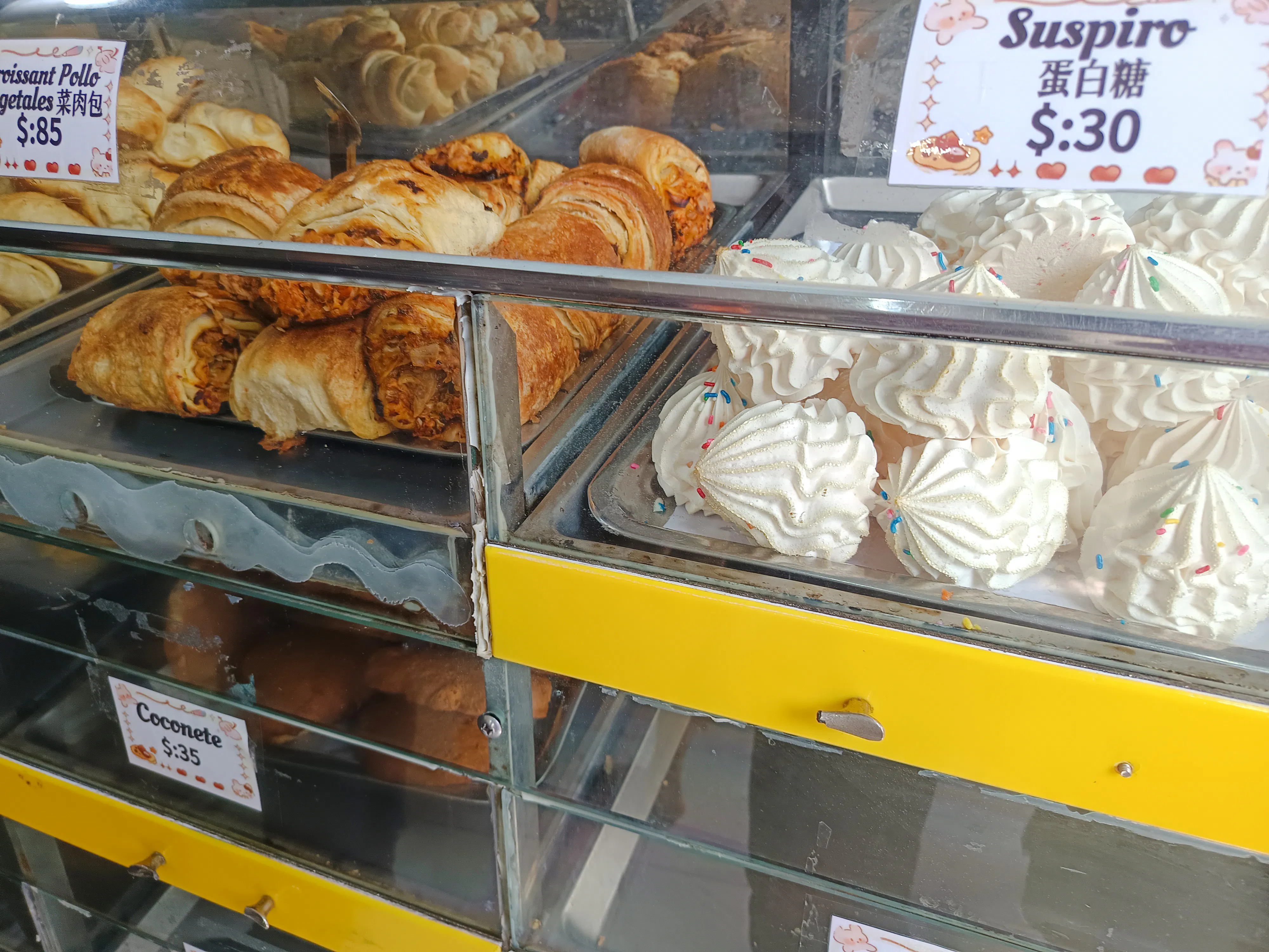 Pastries and meringues in a Santo Domingo bakery display during a food walking tour.