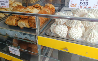 Pastries and meringues in a Santo Domingo bakery display during a food walking tour.