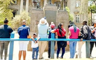 Group of tourists viewing a historical monument in Nairobi during a guided walking tour.
