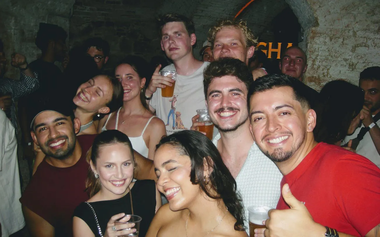 Group enjoying a night out during a Barcelona pub crawl with drinks in hand.
