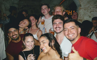 Group enjoying a night out during a Barcelona pub crawl with drinks in hand.