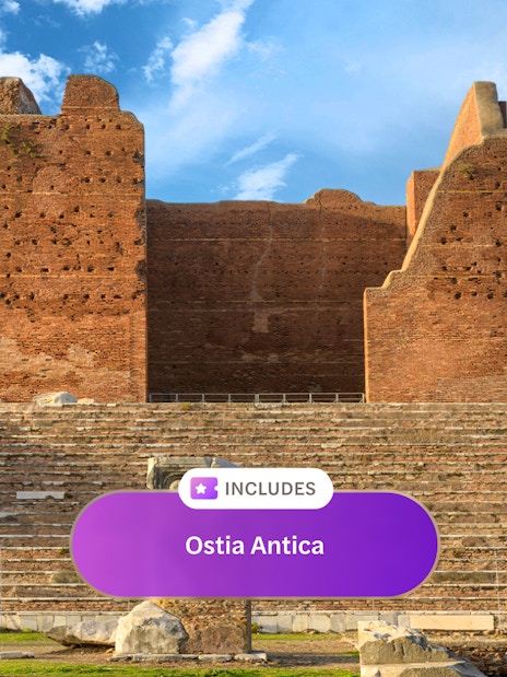 Ancient Roman theater ruins at Ostia Antica under a blue sky.