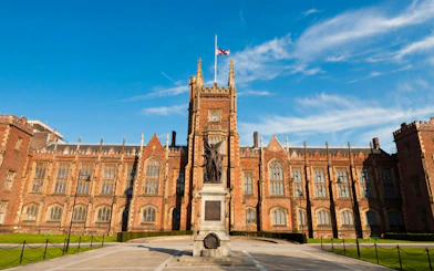 Queen's University Belfast main building with statue in front.