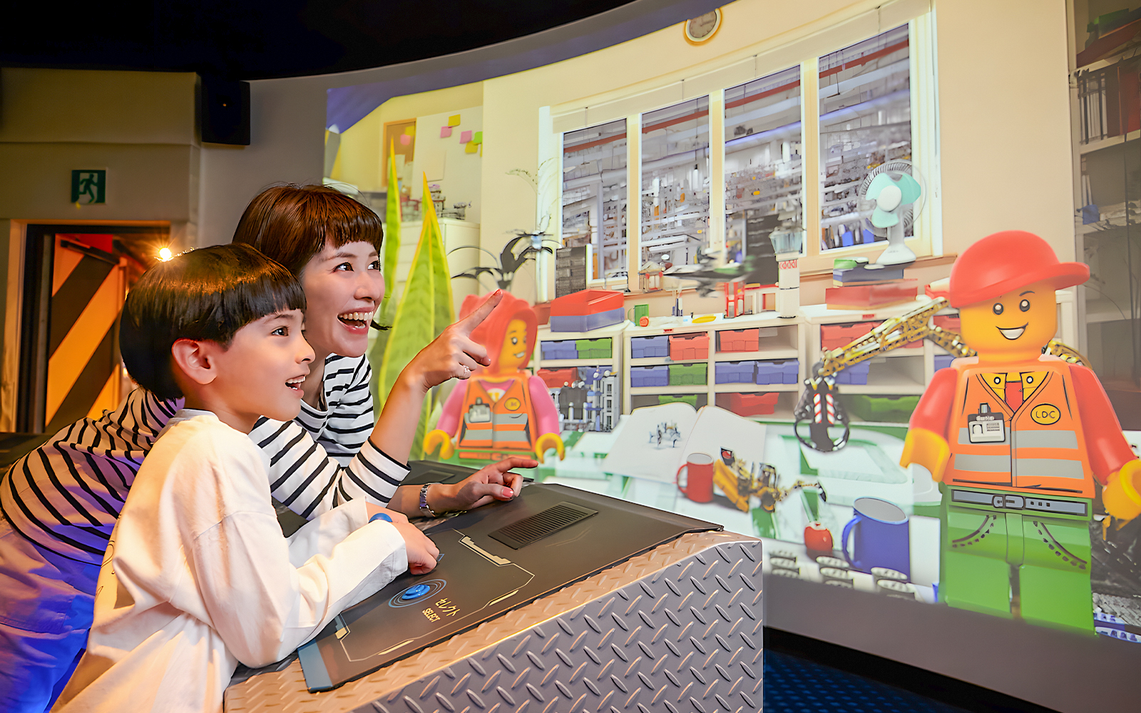 Child and adult enjoying interactive Lego display at Legoland Kansai.