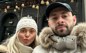 Selfie of two people on the Beer Trail of Bucharest, with pub signs in the background.