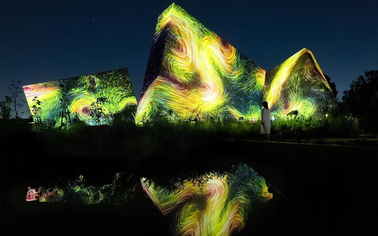 Visitors at teamLab Botanical Garden in Osaka viewing digital art installations.