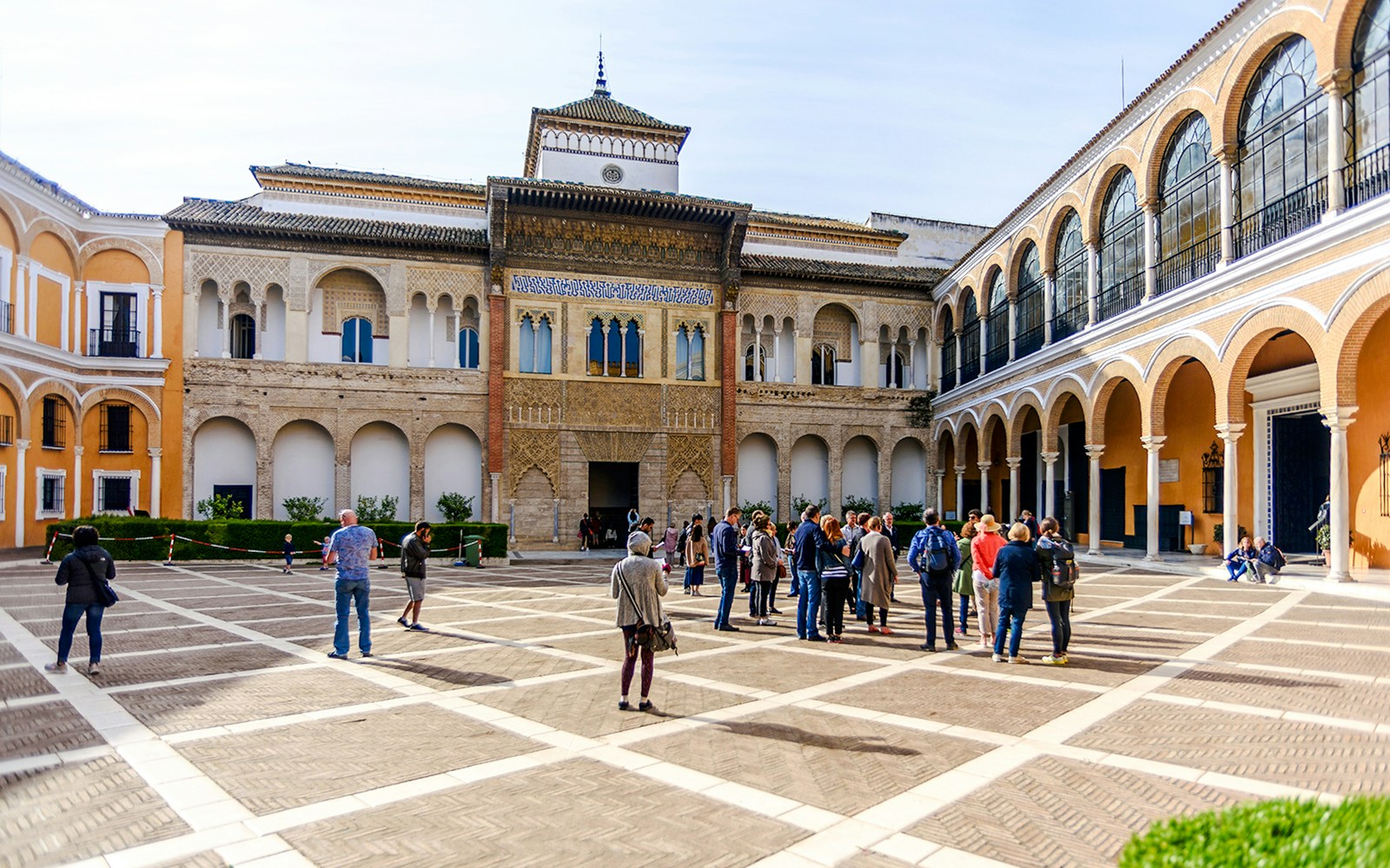 Tourists exploring the courtyard of Alcázar in Seville.