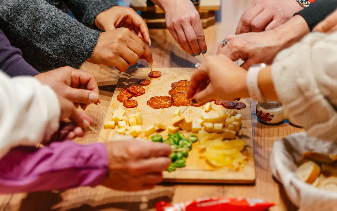 Hands sampling cheese and sausage on a Budapest food tour.