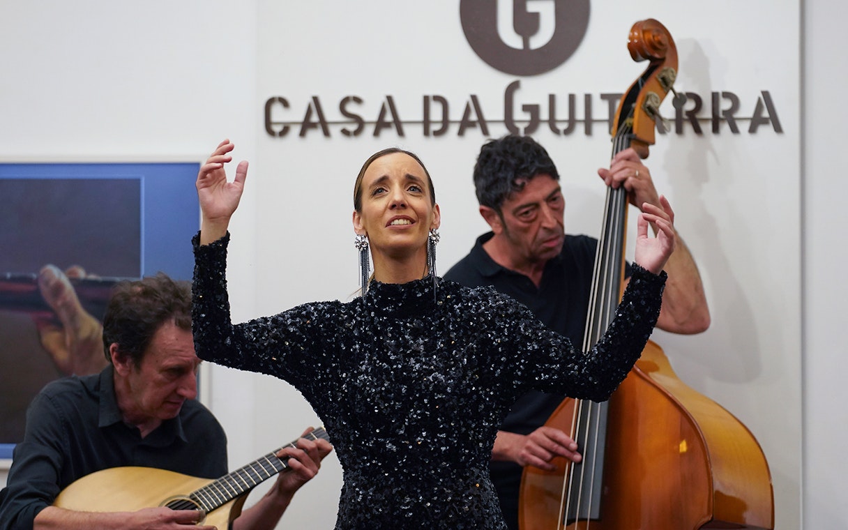 Musicians performing at Casa da Guitarra with a singer and instrumentalists.