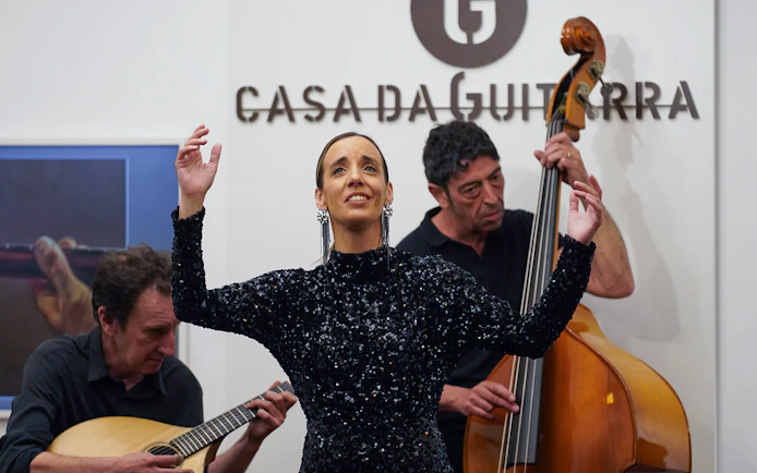 Musicians performing at Casa da Guitarra with a singer and instrumentalists.