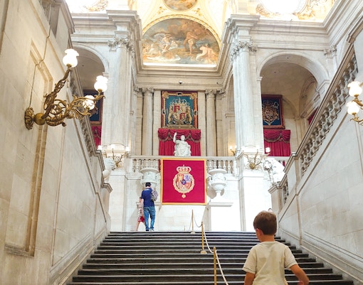 Royal Palace of Madrid exterior with tourists, part of Combo tour with Liria Palace tickets.