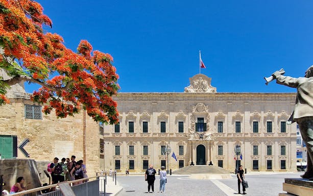 Valletta walking tour with tourists near Auberge de Castille, Malta.
