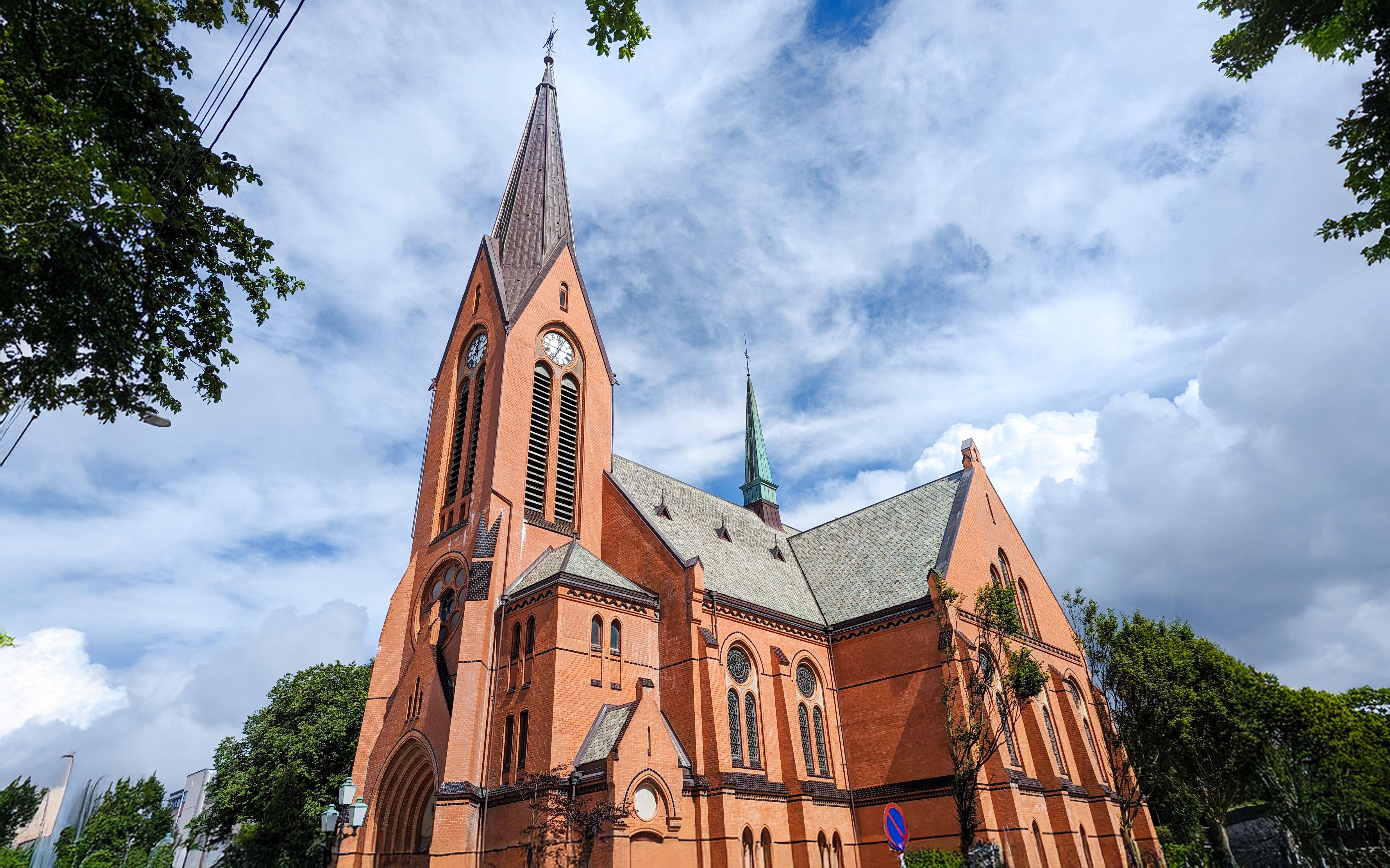 Vår Frelses Church in Haugesund with tall spire and red brick facade.