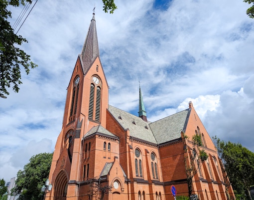 Vår Frelses Church in Haugesund with tall spire and red brick facade.