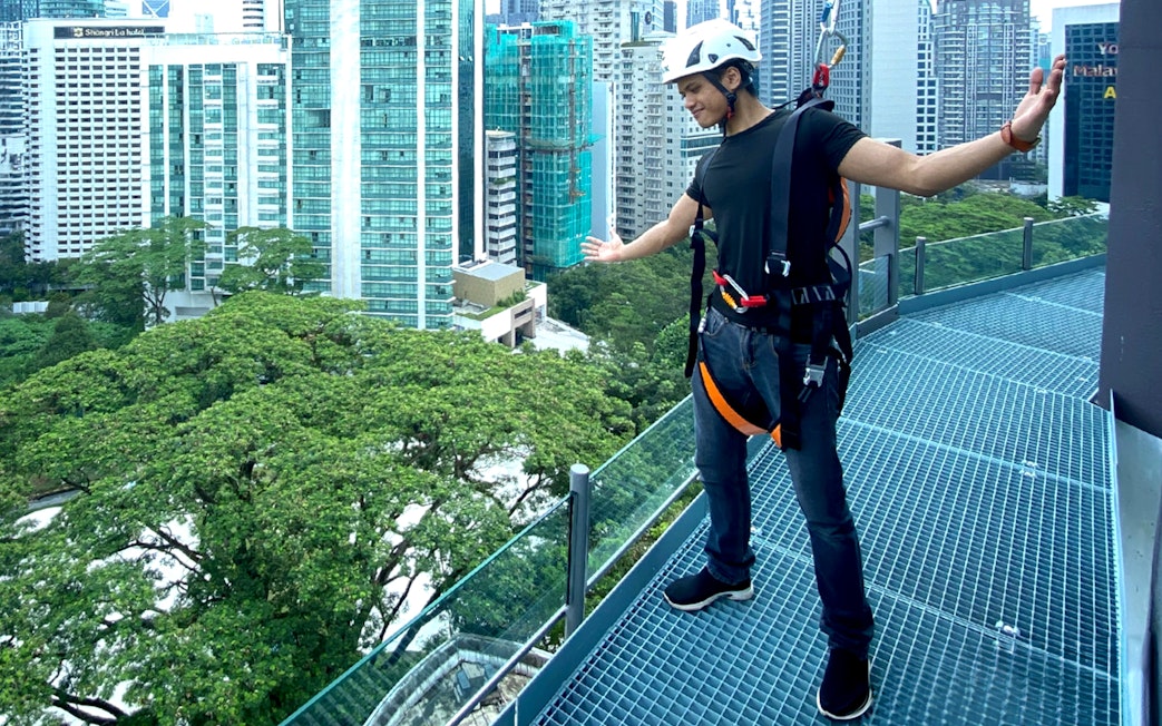 Person enjoying the KL Tower observation deck with Kuala Lumpur cityscape in the background.