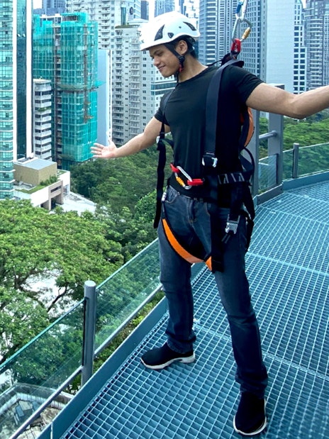 Person enjoying the KL Tower observation deck with Kuala Lumpur cityscape in the background.