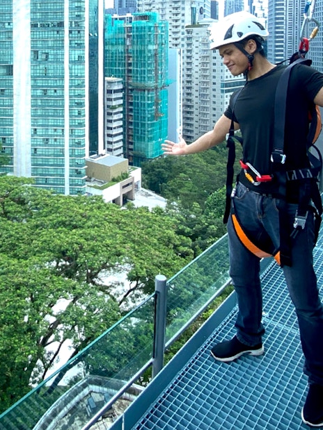 Person enjoying the KL Tower observation deck with Kuala Lumpur cityscape in the background.