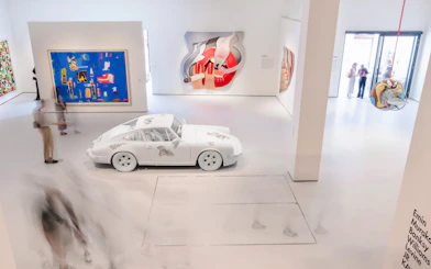 Interiors of Moco Museum London featuring modern art installations and a white car exhibit.
