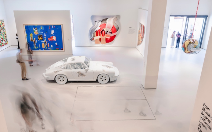 Interiors of Moco Museum London featuring modern art installations and a white car exhibit.