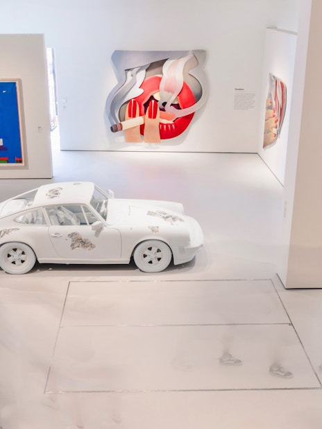 Interiors of Moco Museum London featuring modern art installations and a white car exhibit.