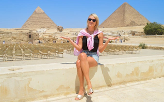 Tourist sitting near Giza Pyramids and Sphinx in Egypt.