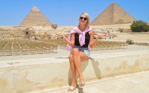 Tourist sitting near Giza Pyramids and Sphinx in Egypt.