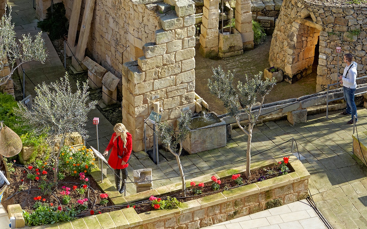 Visitors exploring stone structures and gardens at The Limestone Heritage Park.