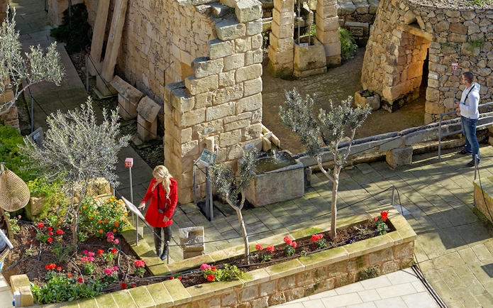Visitors exploring stone structures and gardens at The Limestone Heritage Park.