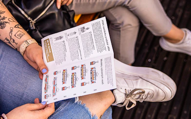 Tourist reading Prague tram tour brochure on a tram.