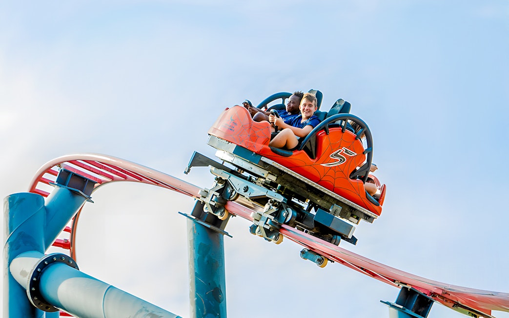 Roller coaster ride Tarantula at Parque de Atracciones de Madrid with smiling riders.