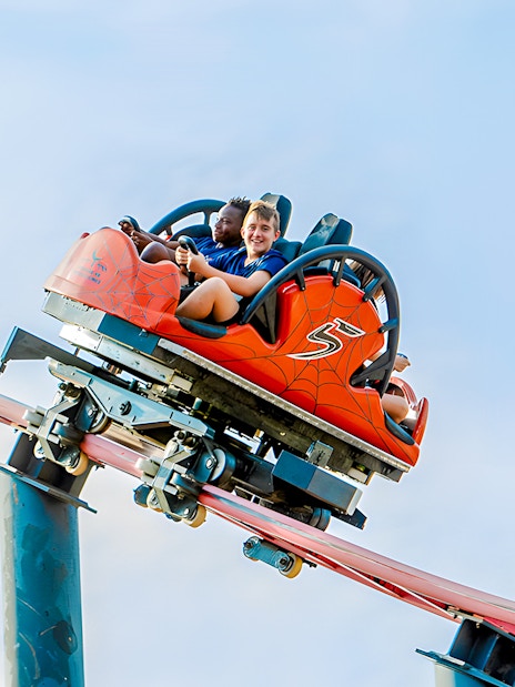 Roller coaster ride Tarantula at Parque de Atracciones de Madrid with smiling riders.